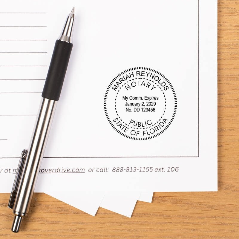 Florida notary stamp impression on document with striped pen on wood desk.