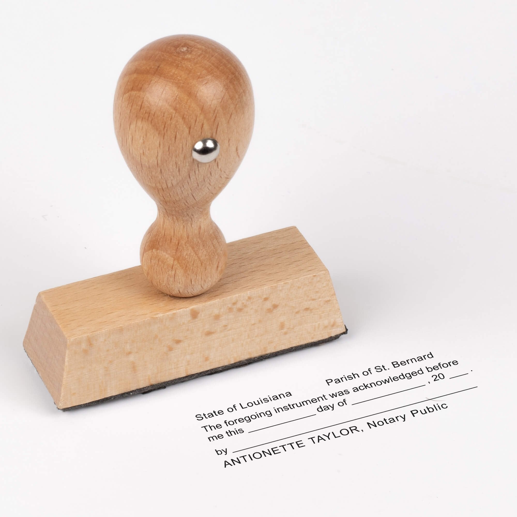 Traditional wood-handle Louisiana notary stamp displayed above its stamped acknowledgment impression.