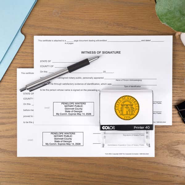 The Custom Georgia Notary Stamp impression on two documents on a desk