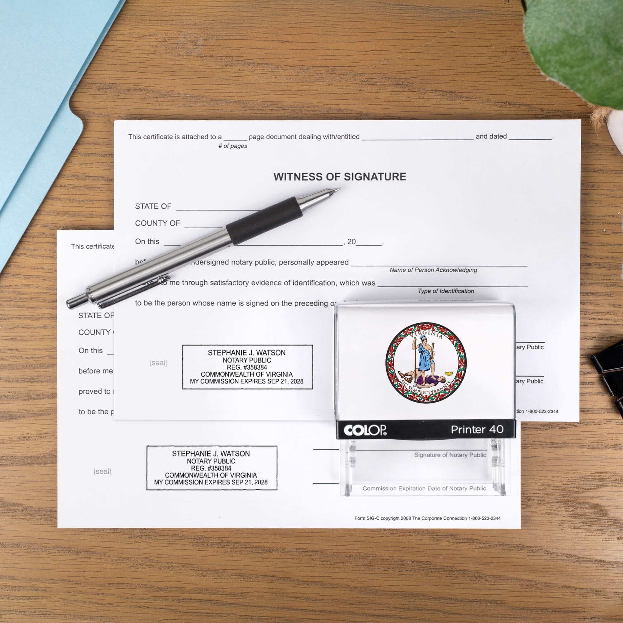 The Virginia Notary Stamp with Custom Logo laysing on paper next to a stamp impression