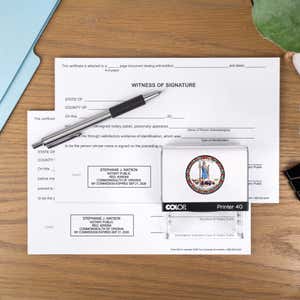 The Virginia Notary Stamp with Custom Logo laysing on paper next to a stamp impression